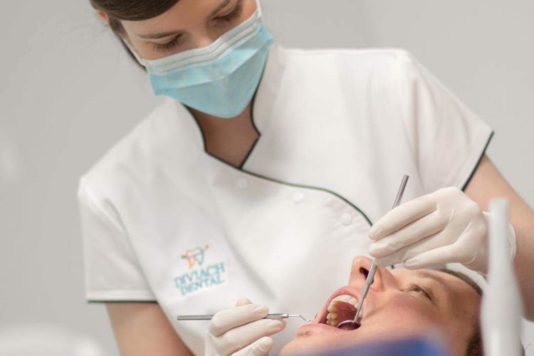 patient receives dental checkup from woman dentist